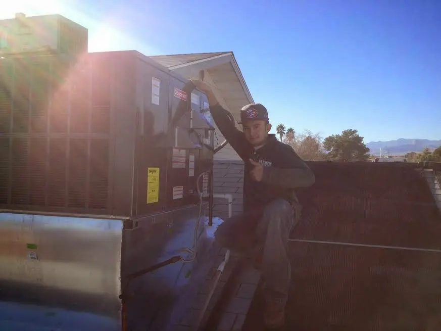 HVAC technician performing AC Tune-Up on a rooftop unit in Manchester